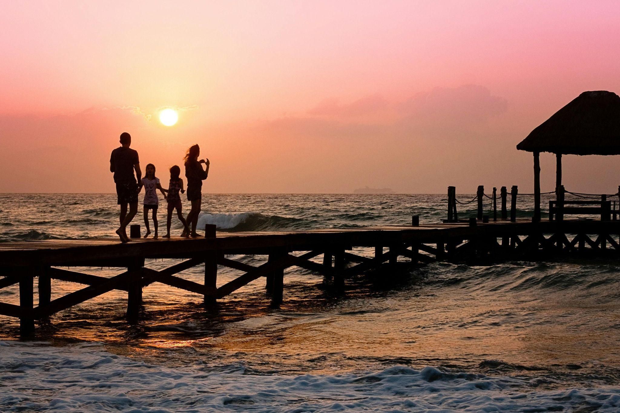 A family standing together on the docks at sunrise
